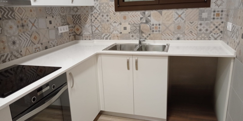 Cocina alicatada con azulejo decorativo y acabado limpio en el Maresme