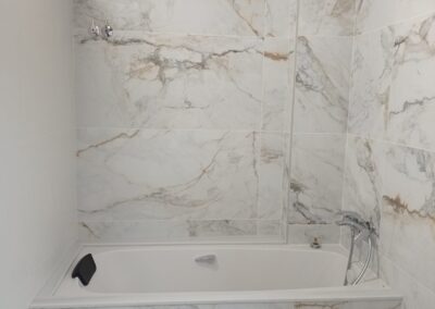 Alicatado de baño en el Maresme con azulejo efecto mármol y acabado profesional