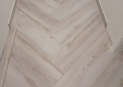 Suelo porcelánico imitación madera colocado en espiga en pasillo en el Maresme